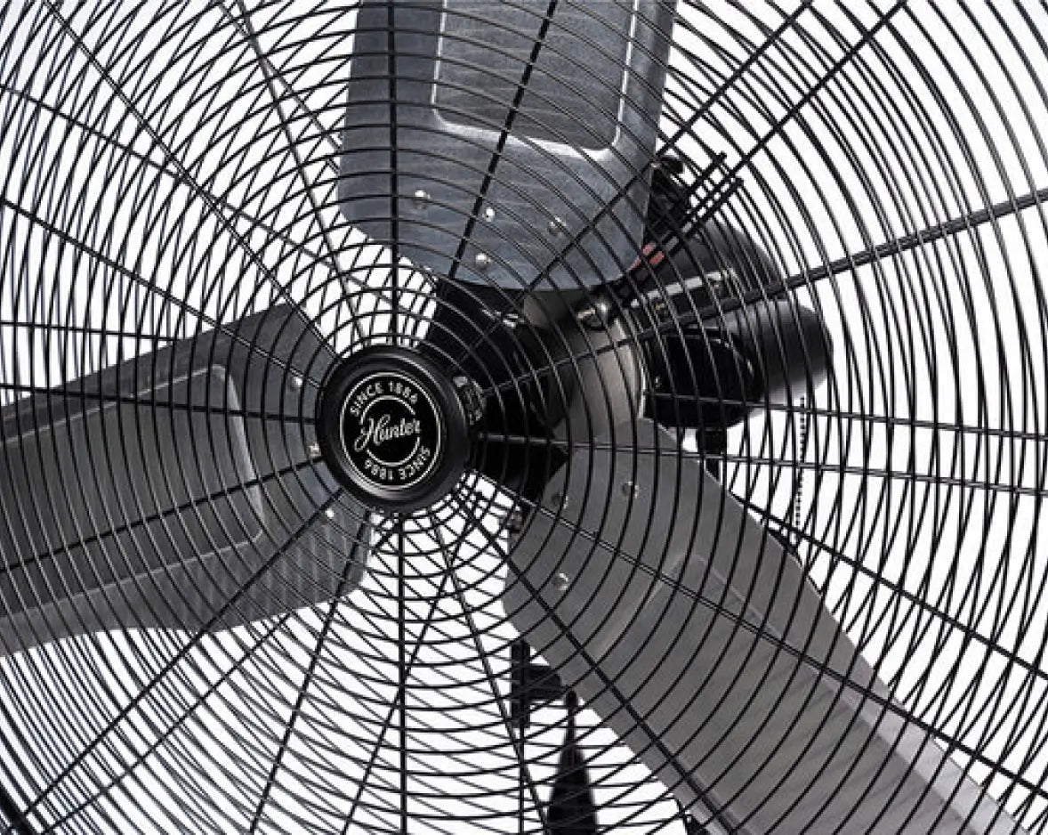 Close-up of an oscillating wall fan on an isolated background.